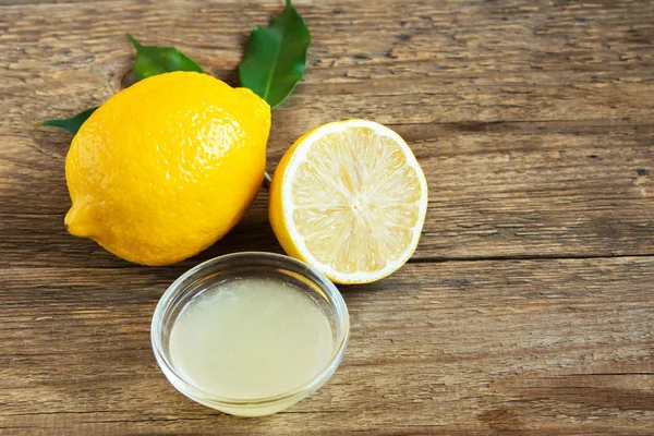 Küçük kase ve limon rustik ahşap arka plan kopya alanı - pişirme ve pişirme için sağlıklı madde ile üzerinde taze limon suyu
