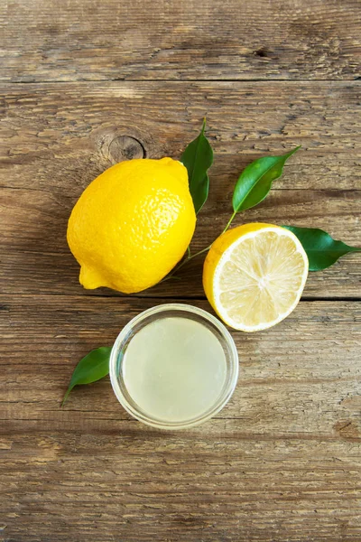 Küçük kase ve limon rustik ahşap arka plan kopya alanı - pişirme ve pişirme için sağlıklı madde ile üzerinde taze limon suyu