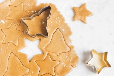 Noel gingerbread çerezleri kesici ile hazırlama, hamur kopya alanı - ev yapımı şenlikli Noel ekmek ile beyaz arka plan üzerinde zencefil