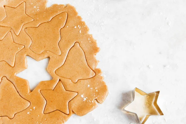 Noel gingerbread çerezleri kesici ile hazırlama, hamur kopya alanı - ev yapımı şenlikli Noel ekmek ile beyaz arka plan üzerinde zencefil