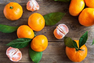 Mandalina (mandalina, clementines, narenciye) üzerinde rustik ahşap arka plan kopya alanı ile yaprakları ile