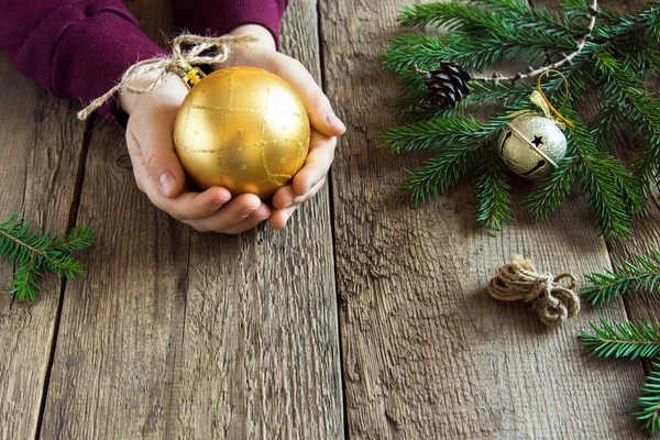 Kerst Gouden Bal Handen Close Rustieke Houten Achtergrond Fir Takken — Stockfoto