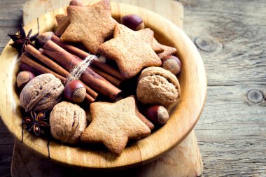 Rustik Noel dekorasyonu ile gingerbread çerezleri, fındık ve Noel baharat ahşap plaka üzerinde kapat