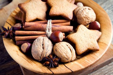 Rustik Noel dekorasyonu ile gingerbread çerezleri, fındık ve Noel baharat ahşap plaka üzerinde kapat