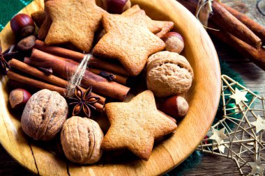 Rustik Noel dekorasyonu ile gingerbread çerezleri, fındık ve Noel baharat ahşap plaka üzerinde kapat