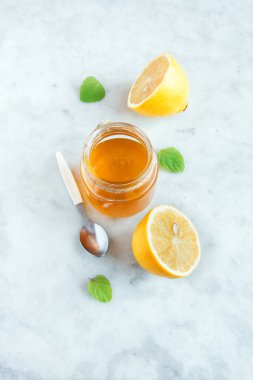 Limon ve bal ile kopya alanı - beyaz taş zemin üzerine alternatif tıp ve sağlıklı yaşam için sağlıklı organik ürünler