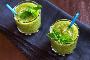 Nane yaprakları rustik ahşap arka plan üzerine gözlük ile yeşil kivi güler yüzlü