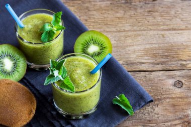 Nane yaprakları rustik ahşap arka plan kopya alanı ile üzerinde gözlük ile yeşil kivi güler yüzlü