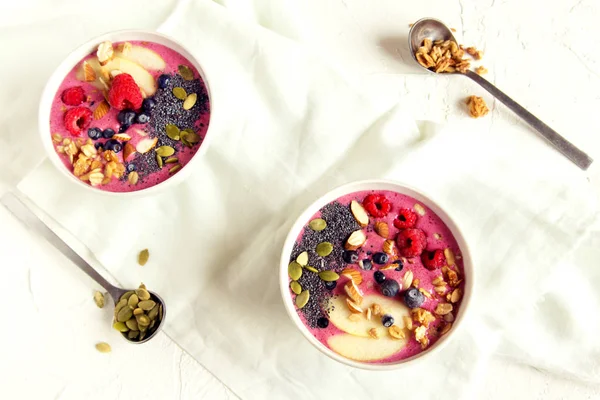 Taze meyveler, fındık, tohumlar ve sağlıklı kahvaltı için ev yapımı granola ile güler yüzlü kase