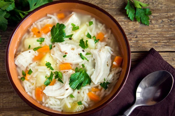 チキンのスープと麺と野菜の素朴な木製の背景 自家製の健康的な食事にボウルに入れて — ストック写真