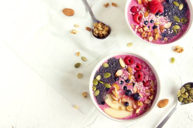 Sağlıklı vejetaryen diyeti kahvaltısı için taze böğürtlen, fındık, tohum ve ev yapımı granola ile meyve suyu kasesi.