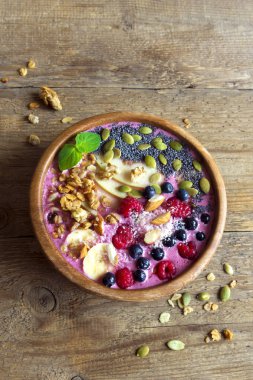 Sağlıklı vejetaryen diyeti kahvaltısı için taze böğürtlen, fındık, tohum ve ev yapımı granola ile meyve suyu kasesi.