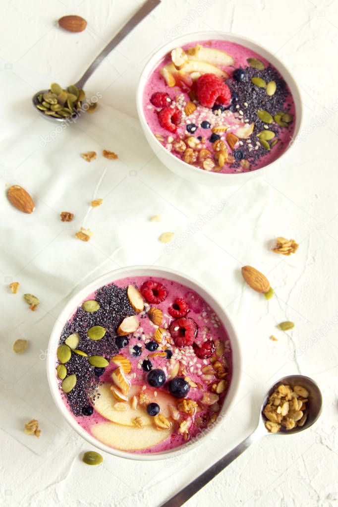 Smoothie bowl with fresh berries, nuts, seeds and homemade granola for healthy vegan vegetarian diet breakfast