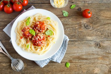 Spagetti makarna köfte, domates sosu, rendelenmiş parmesan peyniri ve taze fesleğen - rustik ahşap arka plan kopya alanı ile sağlıklı ev yapımı İtalyan Makarna