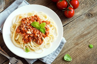 Spagetti bolognese makarna salça ve kıyma, rendelenmiş parmesan peyniri ve taze fesleğen - kopya alanı rustik ahşap zemin üzerine ev yapımı sağlıklı İtalyan Makarna