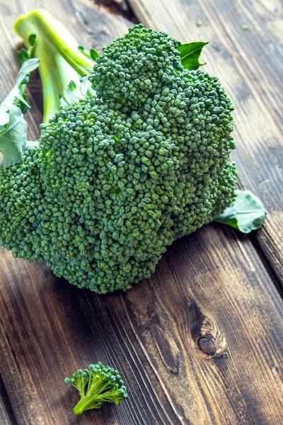 Healthy green organic raw broccoli on wooden table - ingredient ready for cooking healthy food