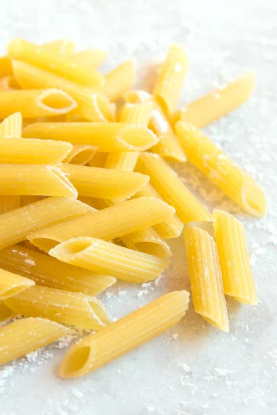 Rauwe Ongekookte Pasta Penne Witte Stenen Achtergrond Close — Stockfoto