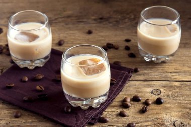 Buz, çikolata şekerleme ve rustik ahşap arka plan - ev yapımı şenlikli alkollü içki üzerine kahve çekirdekleri ile İrlandalı krem kahve likörü