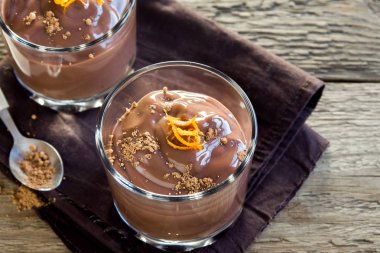 Çikolatalı mus ahşap arka plan yakın up - lezzetli ev yapımı çikolatalı puding üzerinde bardaklarda portakal lezzet ile tepesinde