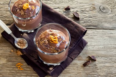 Çikolatalı mus ahşap arka plan yakın up - lezzetli ev yapımı çikolatalı puding üzerinde bardaklarda portakal lezzet ile tepesinde