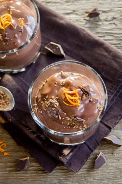 Çikolatalı mus ahşap arka plan yakın up - lezzetli ev yapımı çikolatalı puding üzerinde bardaklarda portakal lezzet ile tepesinde