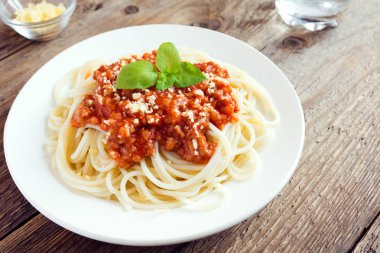 Spagetti bolognese makarna salça ve kıyma, rendelenmiş parmesan peyniri ve taze fesleğen - rustik ahşap zemin üzerine ev yapımı sağlıklı İtalyan Makarna