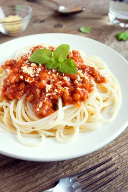 Spagetti bolognese makarna salça ve kıyma, rendelenmiş parmesan peyniri ve taze fesleğen - rustik ahşap zemin üzerine ev yapımı sağlıklı İtalyan Makarna