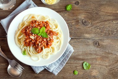 Spagetti bolognese makarna salça ve kıyma, rendelenmiş parmesan peyniri ve taze fesleğen - rustik ahşap zemin üzerine ev yapımı sağlıklı İtalyan Makarna