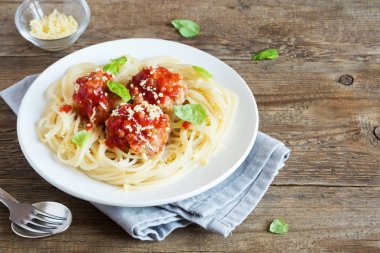 Spagetti makarna köfte, domates sosu, rendelenmiş parmesan peyniri ve taze fesleğen - rustik ahşap arka plan kopya alanı ile sağlıklı ev yapımı İtalyan Makarna