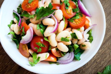 Taze Cannellini fasulye salata domates, soğan ve maydanoz ahşap arka plan üzerinde kopya alanı - sağlıklı ev yapımı organik vejetaryen vegan diyet protein salata yemek yiyecek öğle yemeği