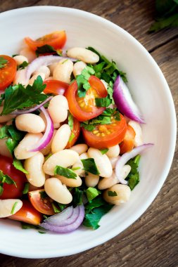 Taze Cannellini fasulye salata domates, soğan ve maydanoz ahşap arka plan üzerinde kopya alanı - sağlıklı ev yapımı organik vejetaryen vegan diyet protein salata yemek yiyecek öğle yemeği