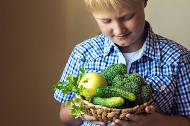 Çocuk (Çocuk) taze malzemeler için sağlıklı gıda sağlıklı organik detoks diyet vegan vejetaryen çiğ beslenme kavramı, organik yeşil sebzeler (brokoli, salatalık, elma ve maydanoz) - sepetle tutun