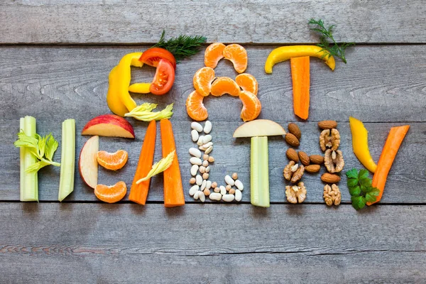 用蔬菜 坚果和豆类写的词 吃健康 在质朴的木质背景 有机成分为健康素食主义者饮食生食和生活方式 — 图库照片