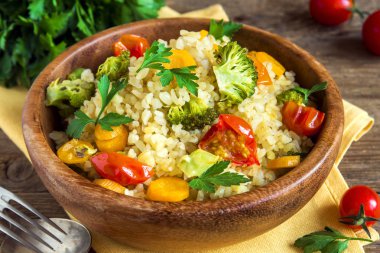 Sebzeli bulgur: domates, havuç, kabak, brokoli ve maydanoz rustik ahşap kase - sağlıklı ev yapımı organik vegan vejetaryen diyet yemek