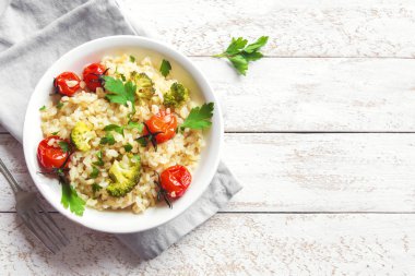 Sebzeli bulgur: domates, brokoli ve beyaz ahşap arka plan - sağlıklı ev yapımı organik vegan vejetaryen diyet yemek üzerine maydanoz