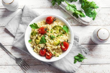 Sebzeli bulgur: domates, brokoli ve beyaz ahşap arka plan - sağlıklı ev yapımı organik vegan vejetaryen diyet yemek üzerine maydanoz