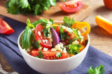 Taze organik domates ve kuskus bulgur salatası Tabbouleh sebze ve Yeşiller - sağlıklı vejetaryen vegan diyet malzemelerle rustik ahşap arka plan üzerinde geleneksel salata