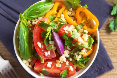 Taze organik domates ve kuskus bulgur salatası Tabbouleh sebze ve Yeşiller - sağlıklı vejetaryen vegan diyet malzemelerle rustik ahşap arka plan üzerinde geleneksel salata