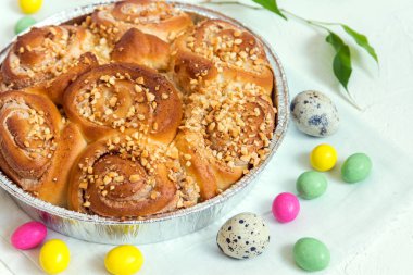 Paskalya pasta. Taze ev yapımı krem tarçınlı çörek fındık ile. Paskalya dekorasyonu ile Paskalya kahvaltıda krem peynirli rulo tarçın yakın çekim.