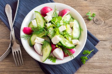 Bahar sebze salatası taze salatalık, turp, beyaz peynir, otlar ile lahanası kase üzerinde ahşap arka plan - sağlıklı organik beslenme vegan vejetaryen salata yemek Gıda detoks