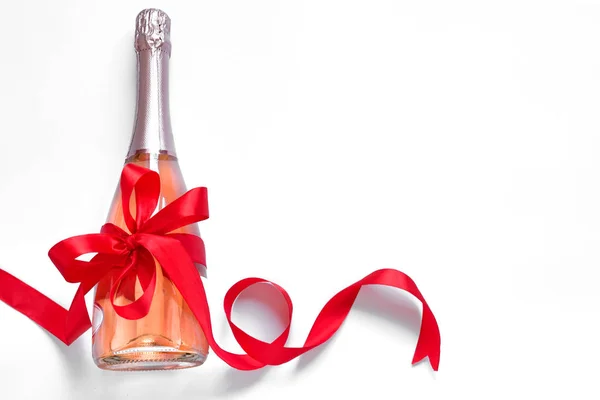 Champagneflaska med röd rosett — Stockfoto
