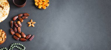 Müslüman Ramazan Kareem, hilal şeklinde meyveler, kara zemin üzerinde su ve ekmek, pankart, kopyalama alanı şeklinde sıralanmış. İftar partisi konsepti.