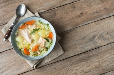 Erişteli tavuk çorbası ve kırsal ahşap arka planda sebzeler, üst manzara, fotokopi alanı. Ev yapımı sağlıklı yemek, taze tavuk ya da hindi çorbası..