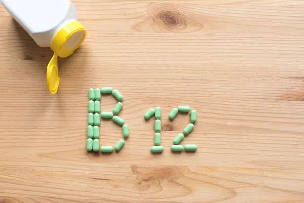 Witamina B12 Zielone Pigułki Tworzące Kształt Alfabetu B12 Drewnianym Tle — Zdjęcie stockowe