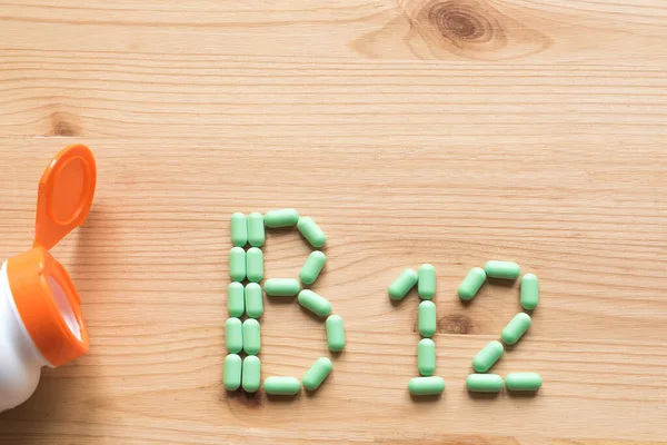 Vitamina B12 Pillole Verdi Che Formano Alfabeto B12 Sfondo Legno — Foto Stock