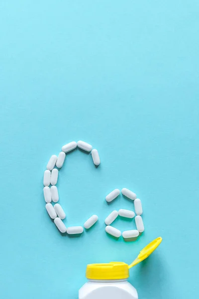 Tabletki Wapnia Białe Tabletki Tworzące Kształt Alfabetu Niebieskim Tle Przestrzeń — Zdjęcie stockowe