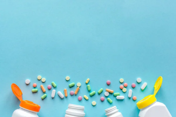 Butelki Różnymi Kolorowymi Tabletkami Tabletki Niebieskim Tle Widok Góry Przestrzeń — Zdjęcie stockowe