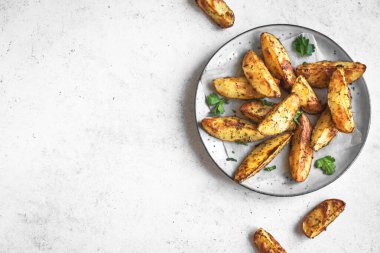 Peynirli ve otlu fırınlanmış patates dilimleri - ev yapımı organik sebze vejetaryen patates dilimleri atıştırmalık yemekler, üst manzara, kopyalama alanı.