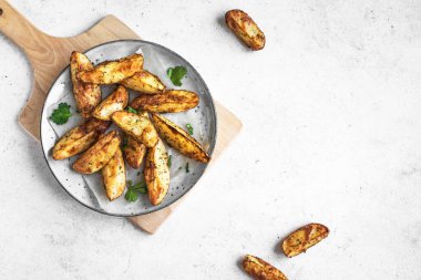 Peynirli ve otlu fırınlanmış patates dilimleri - ev yapımı organik sebze vejetaryen patates dilimleri atıştırmalık yemekler, üst manzara, kopyalama alanı.