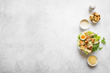 Beyaz arka planda Sezar Salatası, üst manzara, kopyalama alanı. Ev yapımı tavuk sezar salatası ve ızgara kızarmış ekmek..